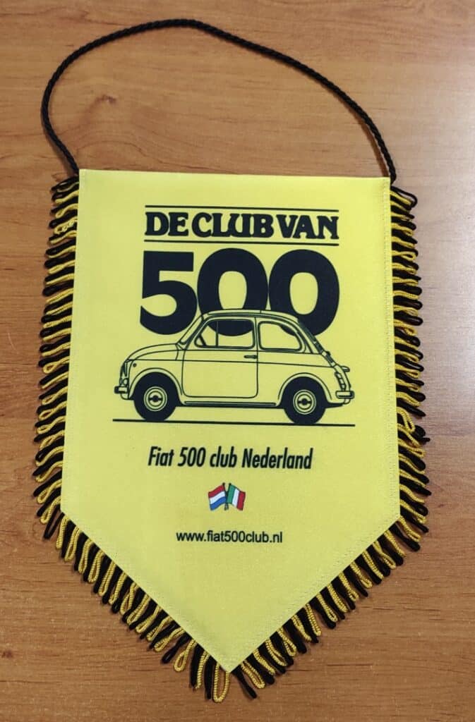 Fanion jaune du Fiat 500 Club Nederland avec dessin de voiture ancienne et franges noires et jaunes.