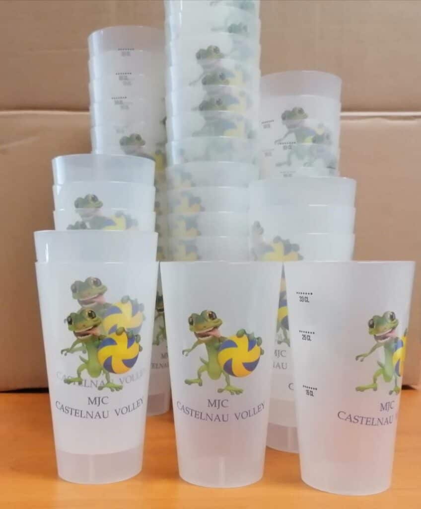 Gobelets MJC Castelnau Volley avec lézard tenant un ballon de volleyball et graduations de mesure.